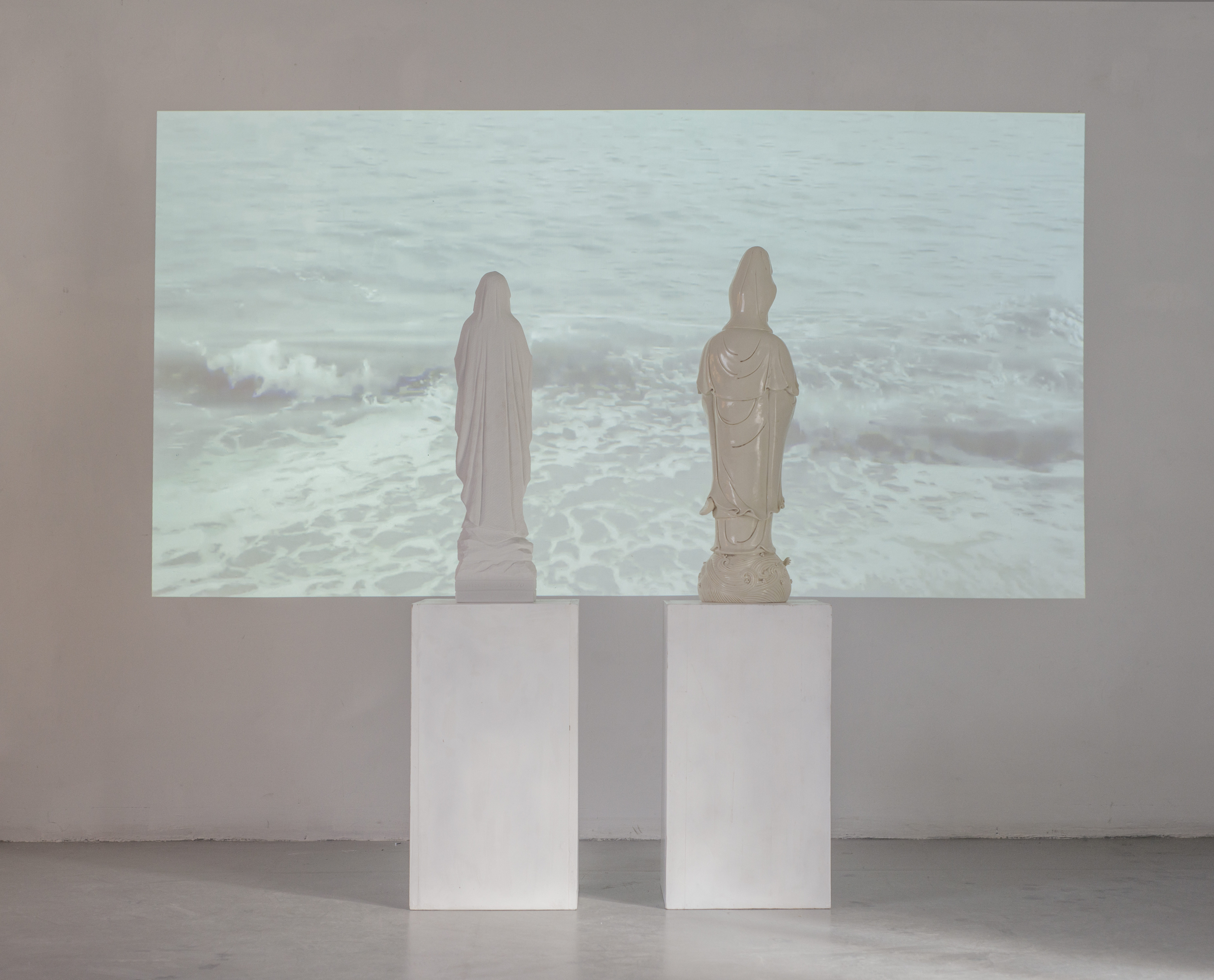 Giuseppina Giordano,HARD WAVES (Kuanyin and Virgin Mary staring at the sea), 2017/marble, Dehua porcelain, video 1:25.33 min/ installation's view