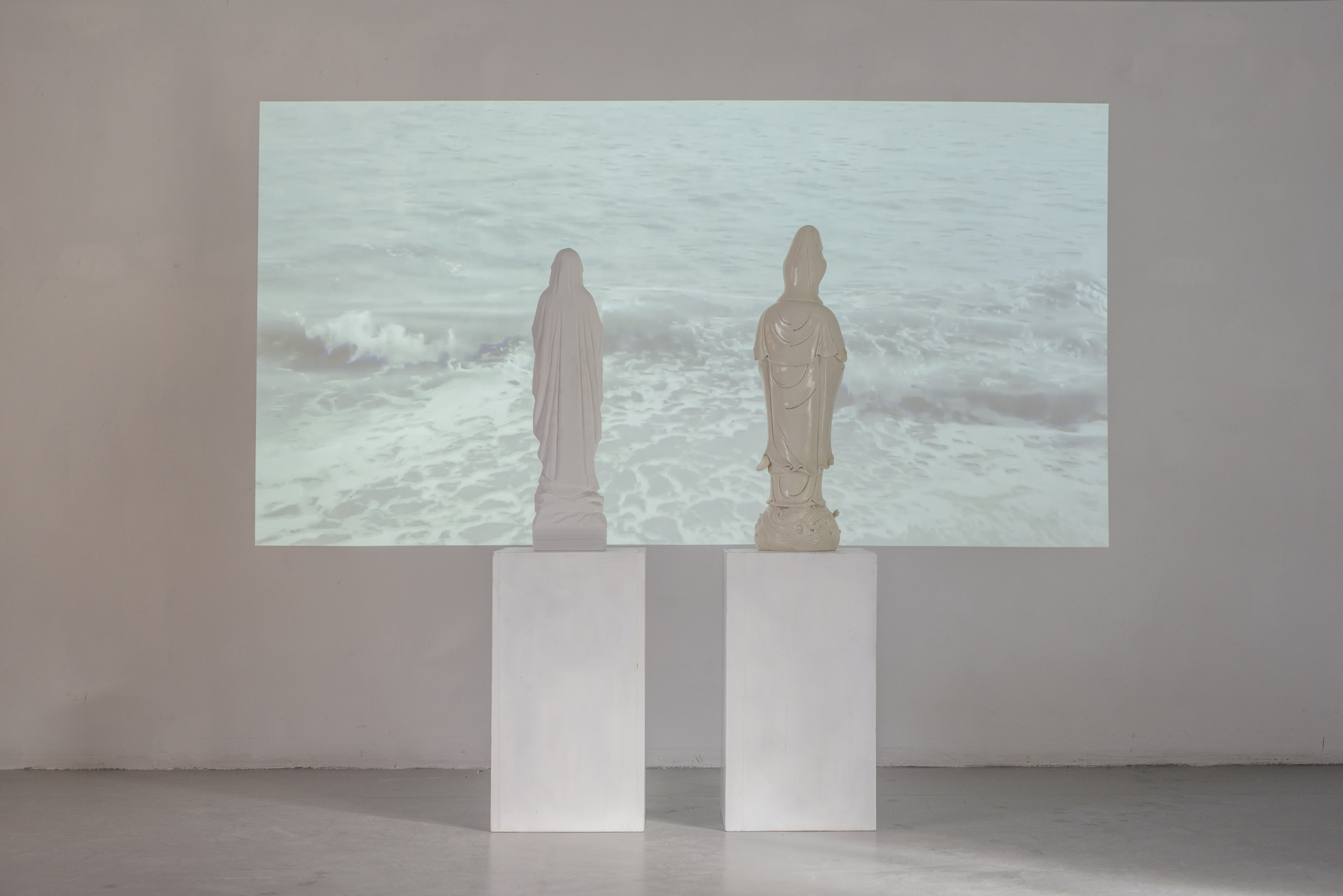 Giuseppina Giordano,HARD WAVES (Kuanyin and Virgin Mary staring at the sea), 2017/marble, Dehua porcelain, video 1:25.33 min/ installation's view